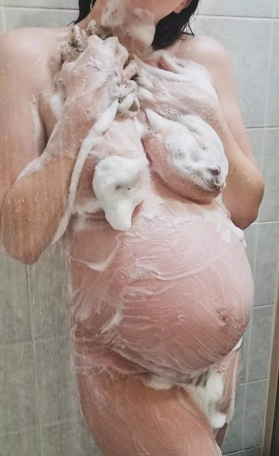 Bubbly pregnant baby belly in the shower