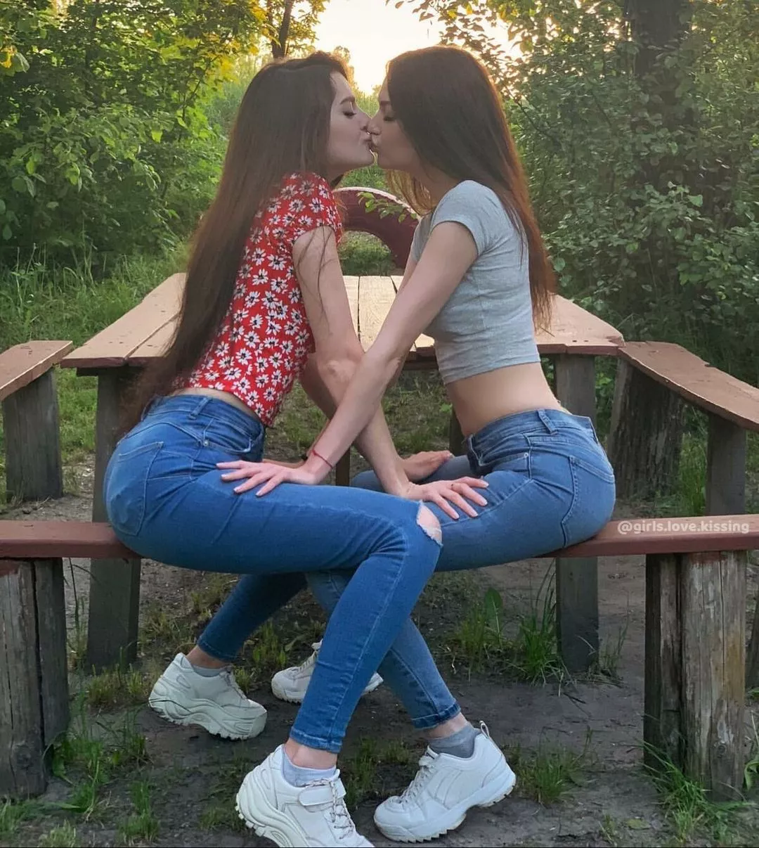 Girls sharing a kiss in the park