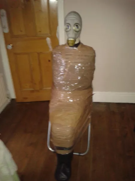 In a latex dollsuit, gagged, then a blsck rubber sleepsack, then parsel taped to a desk chair & a rubber gas mask on XD absolute bliss!! No way of escape! (Old photo)