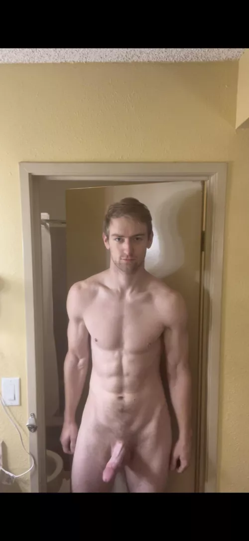 Large man erect outside hotel bathroom.