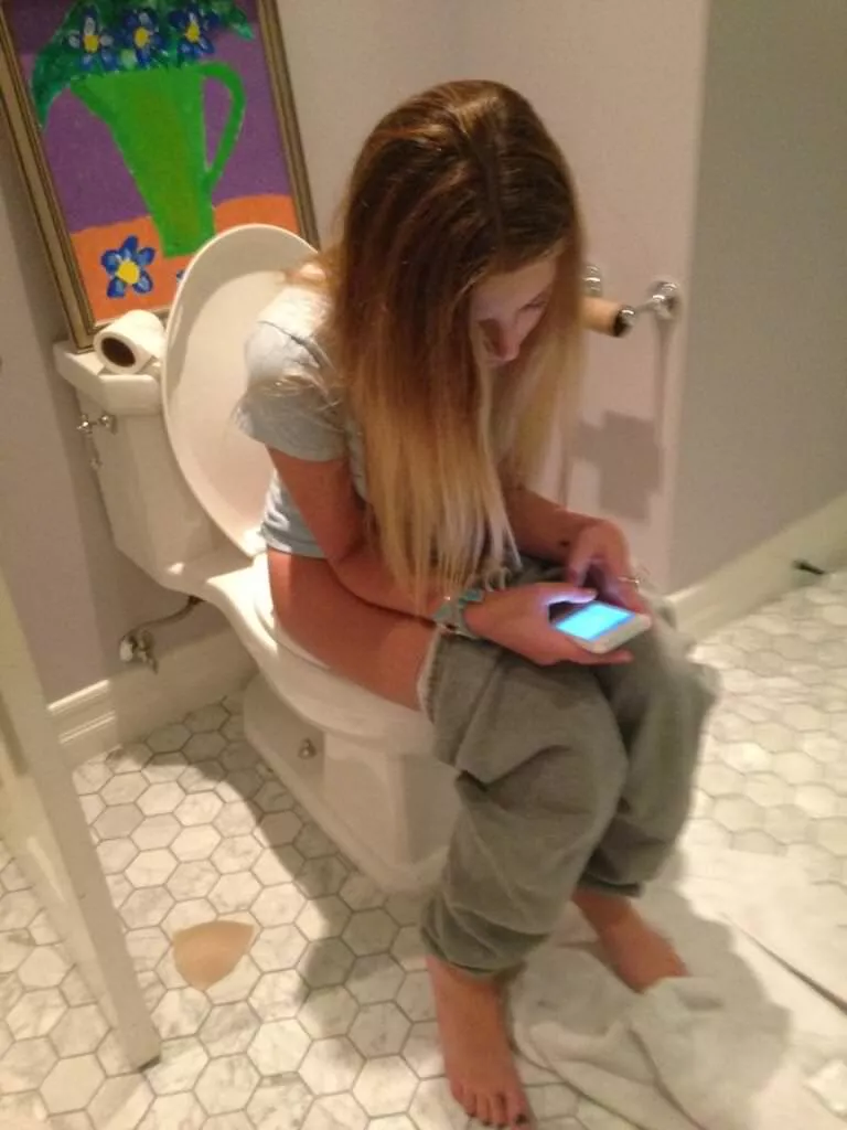 On her phone while going potty On her phone while going potty