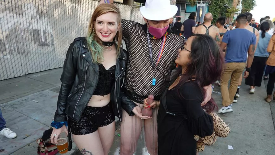 One cradling his balls, one holding his stiff cock - all in public and all happy!