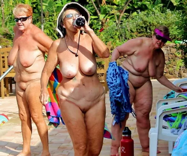 Trio of older nudists by the pool