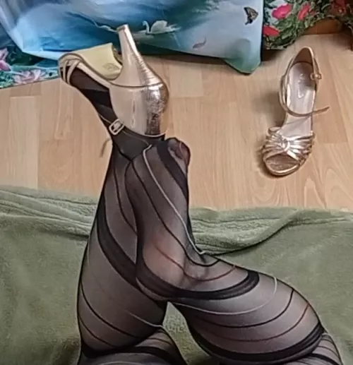 trying to take off my golden heels with my foot
