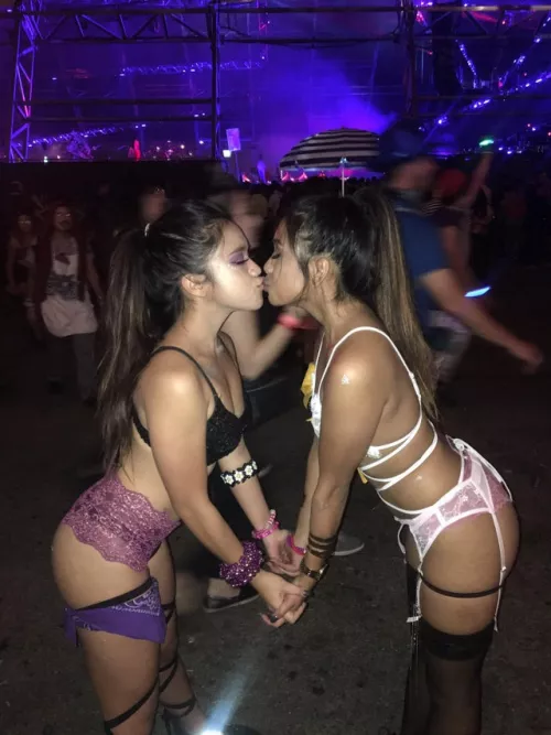 Two beautiful girls kissing at a music festival