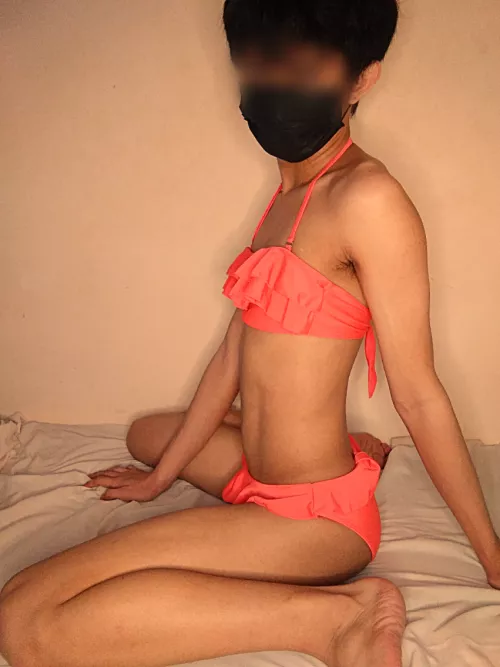 Wearin' a pink bikini.